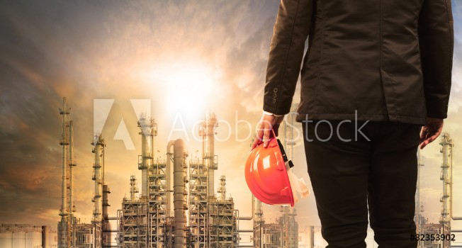 Picture of engineering man with safety helmet standing in industry estate a